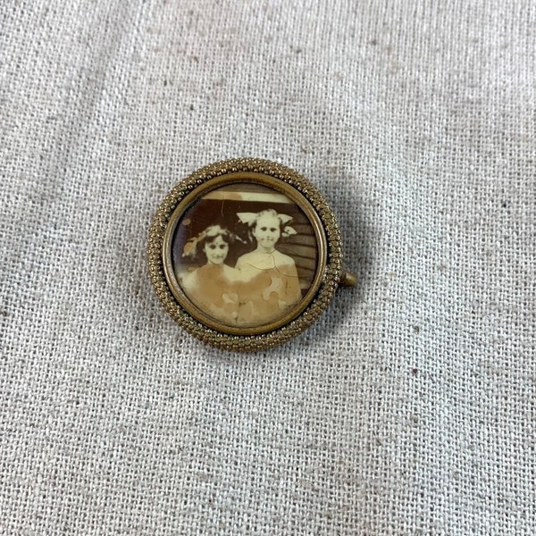 Victorian Era Mourning Brooch, 1 1/8" in diameter, gold tone base metal, maybe filled, two female subjects, maybe sisters, open C clasp