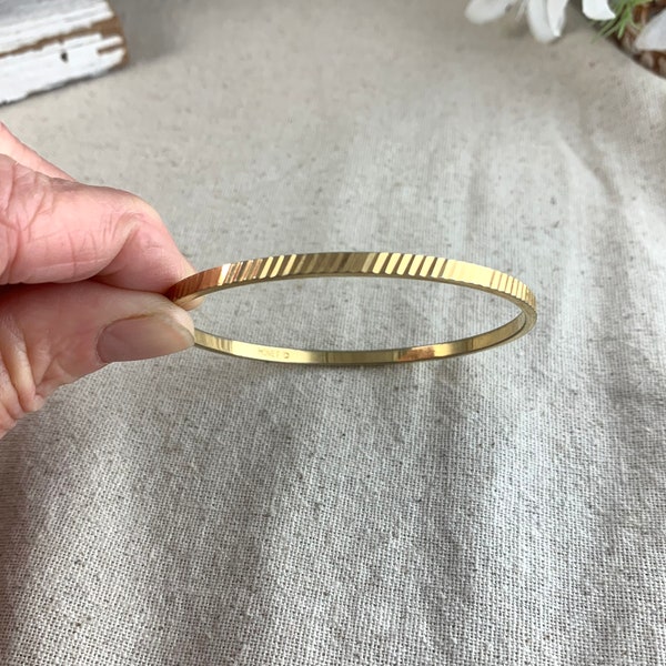 Monet Bangle Bracelet, 2 1/2" inside measurement right to left, 1/8" wide (3 mm), ridged design, gold tone base metal, vintage, signed