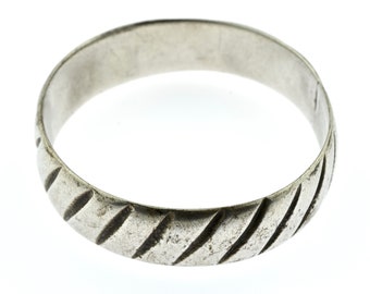 May include: A silver ring with a textured, diagonal pattern around the band.