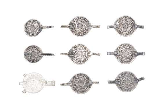 Lot of nine silver Cherifian dirhams mounted as pendants. Ancient tribal Berber pendants from Morocco.