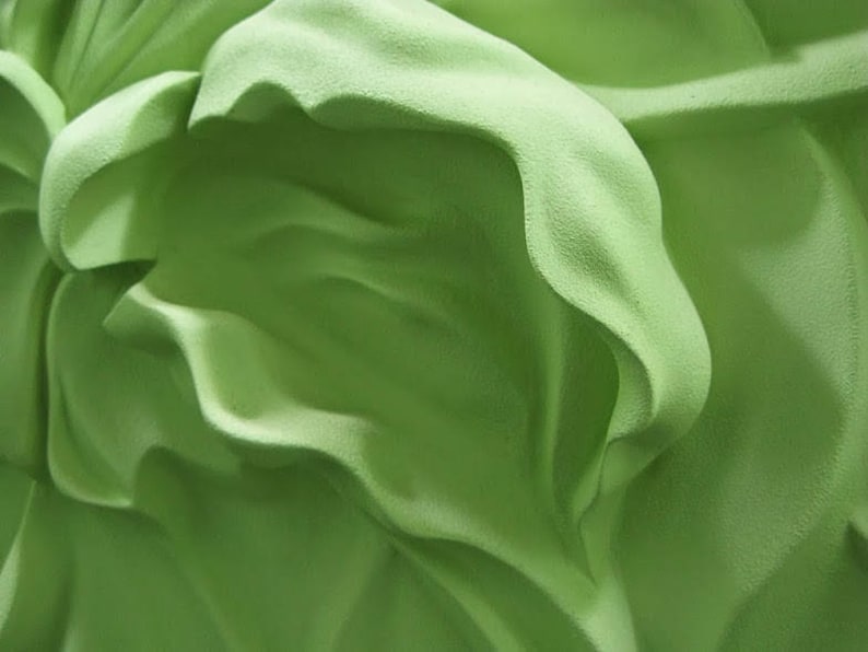 May include: Abstract green fabric with a textured surface and flowing folds.