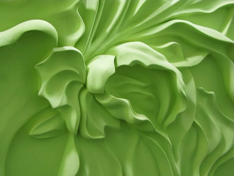 May include: A close-up of a green, 3D floral wall decor with a textured, sculpted design.