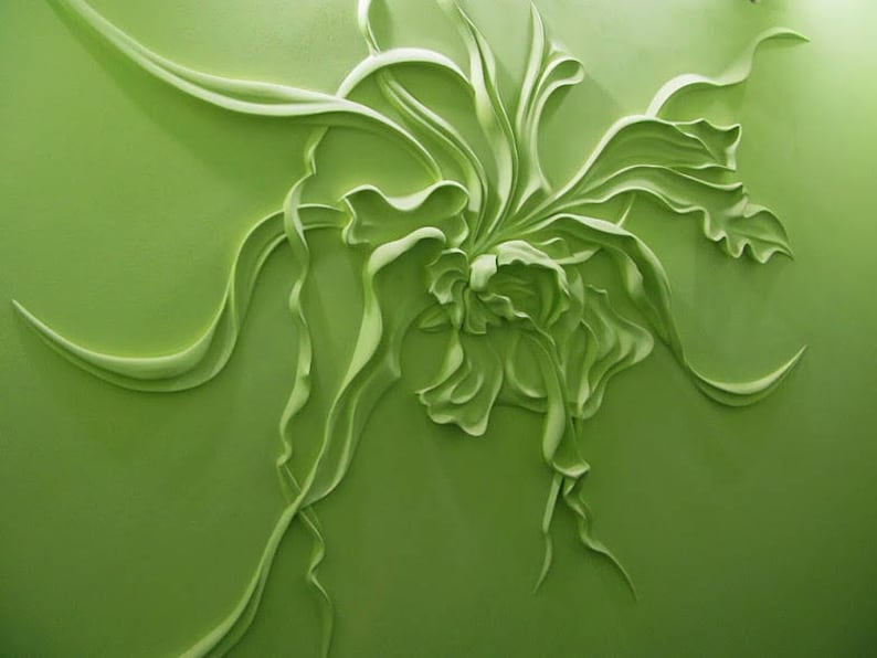 May include: A green 3D wall sculpture of a stylized flower with intricate details. The flower is made of a smooth, textured material and has a delicate, flowing design.
