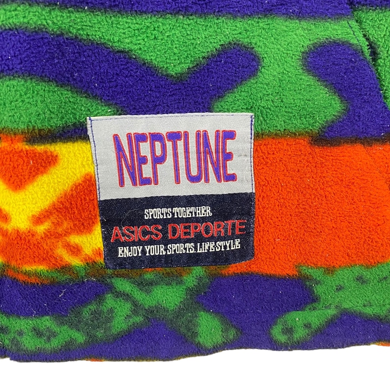 Puede incluir: Una chaqueta de forro polar de colores con un parche que dice "NEPTUNE SPORTS TOGETHER ASICS DEPORTE ENJOY YOUR SPORTS LIFESTYLE"