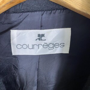 May include: A white label with black text that reads "Courr&egrave;ges" with a stylized "C" logo above the text.