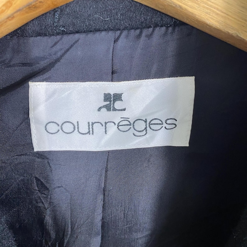 May include: A white label with black text that reads "Courr&egrave;ges" with a stylized "C" logo above the text.