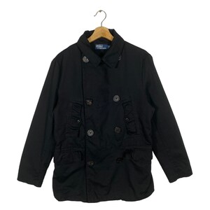 May include: A black double-breasted peacoat with a large collar and multiple pockets. The coat has a label that reads "Polo by Ralph Lauren".