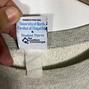 May include: White tag with black text that reads "MADE IN THE USA University of North Carolina at Chapel Hill & Student Stores The Cotton Exchange".