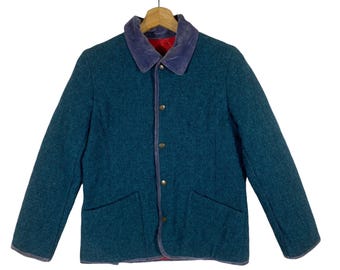 May include: A teal blue jacket with a purple corduroy collar and red lining. The jacket has a button closure and two pockets.