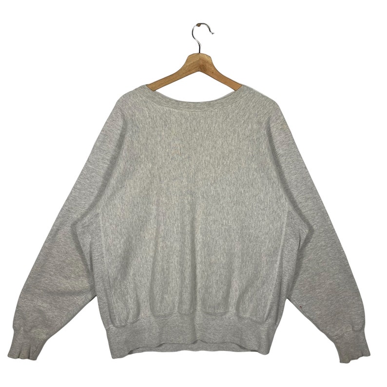 May include: A heather grey sweatshirt with long sleeves and a crew neck.
