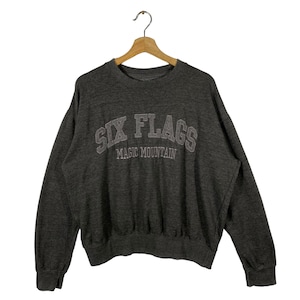 Puede incluir: Sudadera gris con el texto "Six Flags Magic Mountain" en letras bordadas blancas.