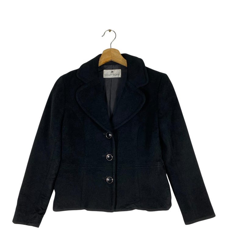 May include: A black blazer with a notched collar and four buttons. The blazer has a label that says "Courts & Co."