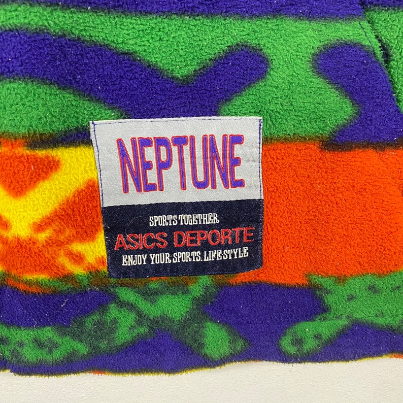 Puede incluir: Una chaqueta de forro polar colorida con un parche que dice "NEPTUNE SPORTS TOGETHER ASICS DEPORTE ENJOY YOUR SPORTS LIFE-STYLE".