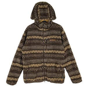 Puede incluir: Una chaqueta de forro polar con estampado marr&oacute;n y beige, con cierre de cremallera y capucha. La chaqueta tiene un patr&oacute;n geom&eacute;trico con rayas y puntos marrones y beige.