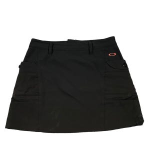 May include: Black cargo skirt with a small orange logo on the right side. The skirt has two large pockets on the front and two smaller pockets on the back.