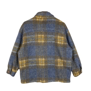 May include: A blue and gold plaid jacket with a button-down front and two chest pockets. The jacket is made of a soft, textured fabric and has long sleeves. The back of the jacket is visible in the image.