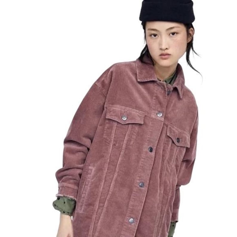 K&ouml;nnte beinhalten: Staubrosa Cordjacke mit zwei Brusttaschen und Knopfverschl&uuml;ssen. Die Jacke hat einen klassischen Kragen und lange &Auml;rmel. Das Model tr&auml;gt einen schwarzen Hut. Eine stilvolle Oberbekleidung.