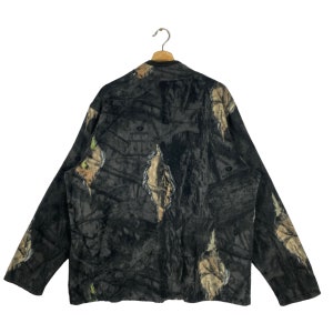 May include: A black fleece jacket with a camouflage pattern. The jacket has a zipper closure and long sleeves.