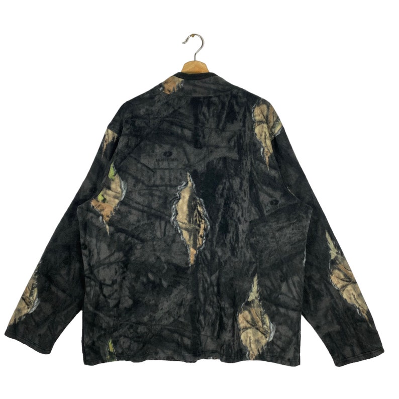 May include: A black fleece jacket with a camouflage pattern. The jacket has a zipper closure and long sleeves.