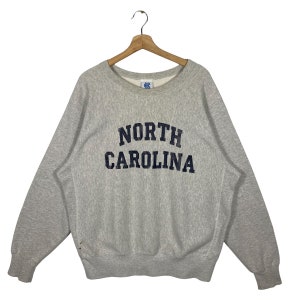 May include: A gray sweatshirt with the text "NORTH CAROLINA" in navy blue lettering.