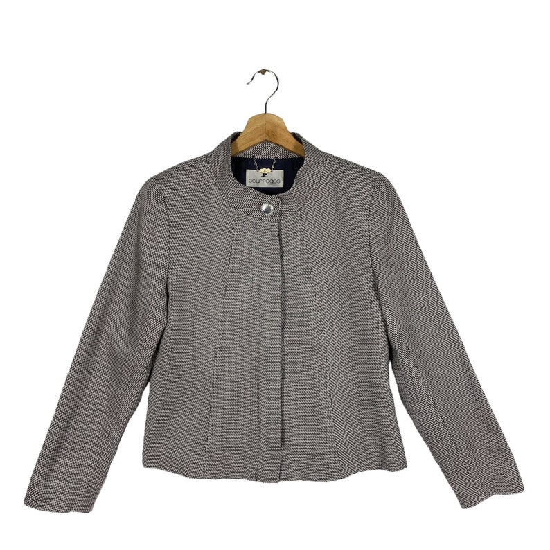Puede incluir: Una chaqueta de punto gris y blanco con cuello alto y cierre de un solo bot&oacute;n. La chaqueta tiene una etiqueta 'fourrage' en la parte delantera.