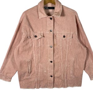 K&ouml;nnte beinhalten: Staubrosa Cordjacke mit Knopfleiste, zwei Brusttaschen und zwei Seitentaschen. Die Jacke hat einen klassischen Kragen und lange &Auml;rmel. Der Saum ist ausgefranst. Das Markenlabel "ZARA" ist sichtbar.