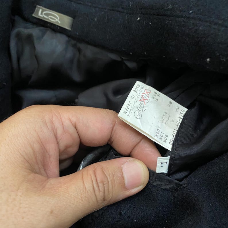 Pu&ograve; includere: Una tazza di ceramica bianca con manico nero e la scritta "But First, Coffee" in grassetto nero. La tazza &egrave; appoggiata su una superficie bianca. La tazza &egrave; alta circa 10 cm.