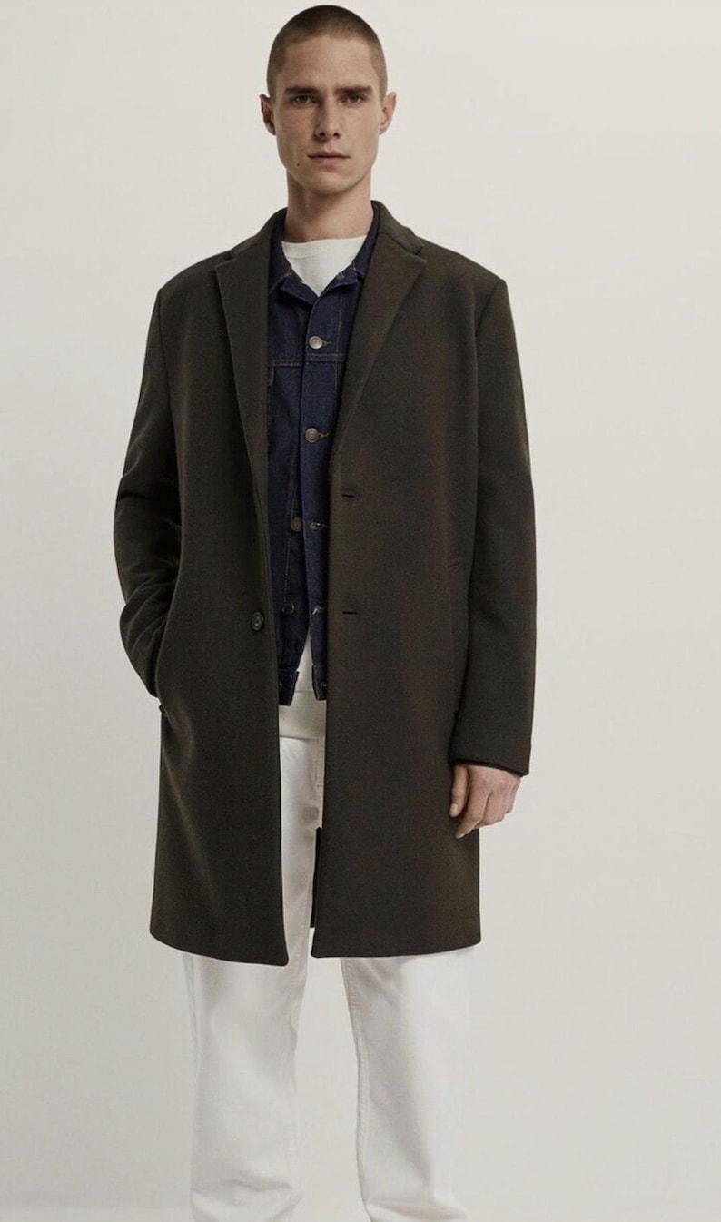 Pu&ograve; includere: Un cappotto lungo verde scuro a maniche lunghe con una chiusura a un solo bottone. Il cappotto ha una vestibilit&agrave; classica e aderente e una lunghezza leggermente pi&ugrave; lunga.