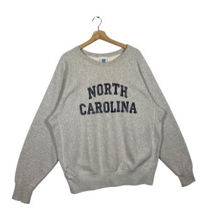 May include: A gray sweatshirt with the text "NORTH CAROLINA" in navy blue lettering.