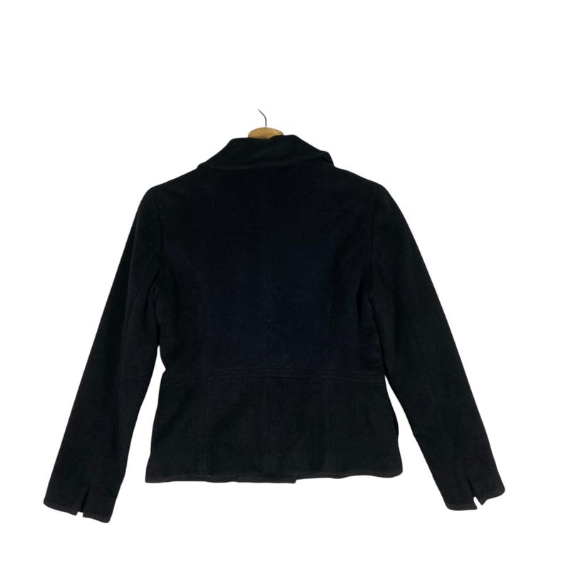 May include: A black peacoat with a classic collar and long sleeves. The coat has a fitted silhouette and a double-breasted closure.