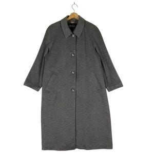 May include: A long gray wool coat with a button closure and two pockets. The coat has a classic collar and a simple design.