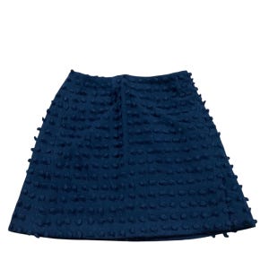 May include: A navy blue skirt with a textured, dotted pattern. The skirt has a classic A-line shape and appears to be made of a soft fabric. The skirt is suitable for casual or semi-formal wear.