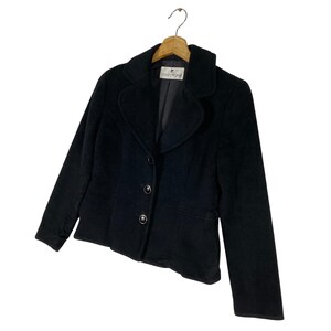 May include: A black blazer with a single button closure and a small label that reads "Countess Mara".
