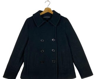 May include: A black peacoat with a double breasted closure and four black buttons. The coat has two pockets on the front.