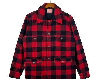 May include: Red and black buffalo plaid jacket with a collared neckline, button-down front, and two chest pockets. The jacket is hanging on a wooden hanger. The Levi's brand tag is visible.