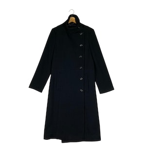 May include: A long black coat with a high collar and a single row of buttons down the front. The coat has a slightly asymmetrical design, with the right side of the front being slightly longer than the left.