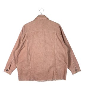 K&ouml;nnte beinhalten: Staubrosa Cordjacke mit klassischem Kragen und Knopfverschl&uuml;ssen. Die Jacke hat lange &Auml;rmel und einen ausgefransten Saum. Die R&uuml;ckseite der Jacke zeigt die vertikale Cordstruktur.