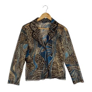 May include: A long-sleeved blazer made of a sheer, mesh-like fabric featuring a multi-colored abstract pattern of brown, tan, and blue swirls with leopard print accents. The garment has a notched collar, two front buttons, and a straight hem.