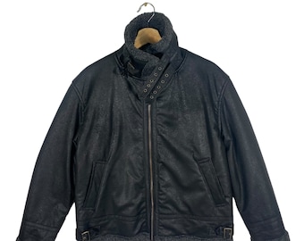 May include: A black faux leather bomber jacket with a shearling collar and lining. The jacket has a zipper closure, two flap pockets, and a buckle detail at the waist.
