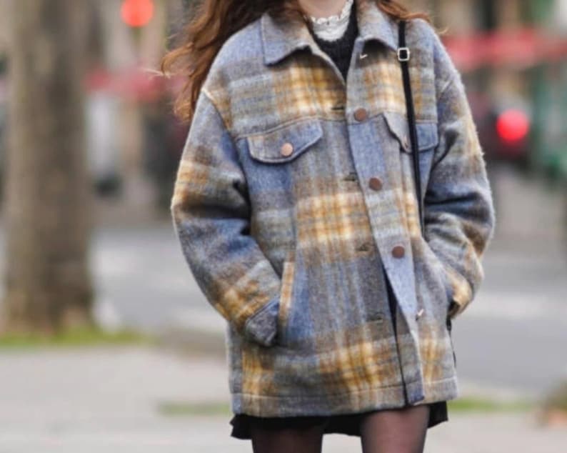 May include: A blue and yellow plaid jacket with a button-up front, two chest pockets, and two side pockets. The jacket has a relaxed fit and is made of a soft, textured fabric. The jacket is a stylish outerwear piece.