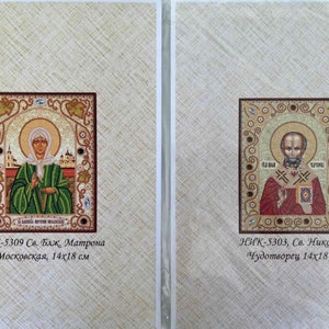 May include: Two framed religious icons with gold trim. The left icon features Saint Matrona of Moscow, and the right icon features Saint Nicholas the Wonderworker. Both icons are 14 by 18 centimeters.