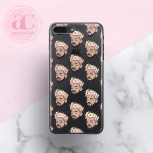 Op de afbeelding: Een transparante telefoonhoes met een zwarte achtergrond en een herhalend patroon van een mannengezicht met een roze en witte bloemenkrans.