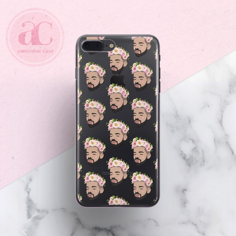 Op de afbeelding: Een transparante telefoonhoes met een zwarte achtergrond en een herhalend patroon van een mannengezicht met een roze en witte bloemenkrans.