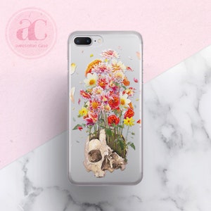 May include: A clear phone case with a colorful floral design and a skull underneath the flowers. The flowers are pink, red, yellow, and white.