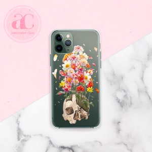 May include: A clear phone case with a green background and a skull with flowers growing out of it. The flowers are red, pink, yellow, and white.