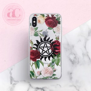 May include: Clear phone case with a floral design featuring red and white roses. The case has a black and white symbol of a pentagram with a sunburst around it. The text "Phone" is visible at the bottom of the case.