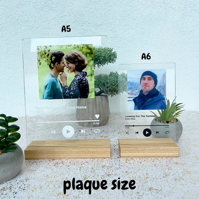 May include: Two clear acrylic music player plaques with a photo and song title. The larger plaque is labelled "A5" and the smaller plaque is labelled "A6". Both plaques have a wooden base.