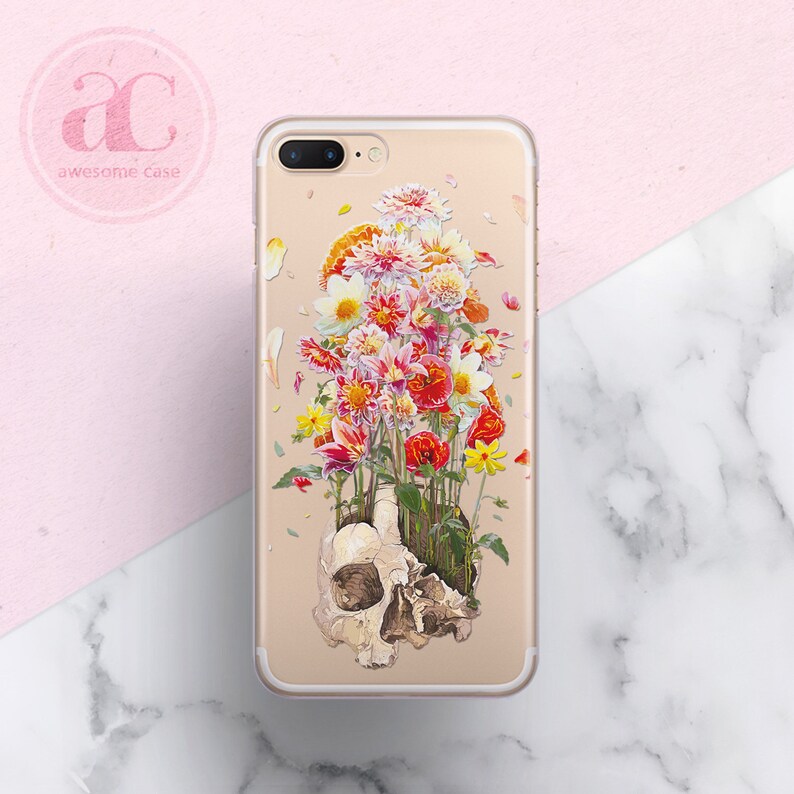 May include: A clear phone case with a colorful floral design and a skull underneath the flowers. The flowers are pink, red, yellow, and white.