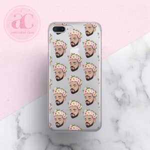 Op de afbeelding: Een transparante telefoonhoes met een patroon van een mannengezicht dat een bloemenkrans draagt. Het mannengezicht wordt herhaald in een rasterpatroon op de hoes.