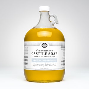 May include: A clear glass jug filled with yellow liquid, labeled "ultra concentrate CASTILE SOAP." The label also states "UNSCENTED | HYPOALLERGENIC" and lists uses like multi-purpose cleaner and body wash. The jug has a white cap and a handle.